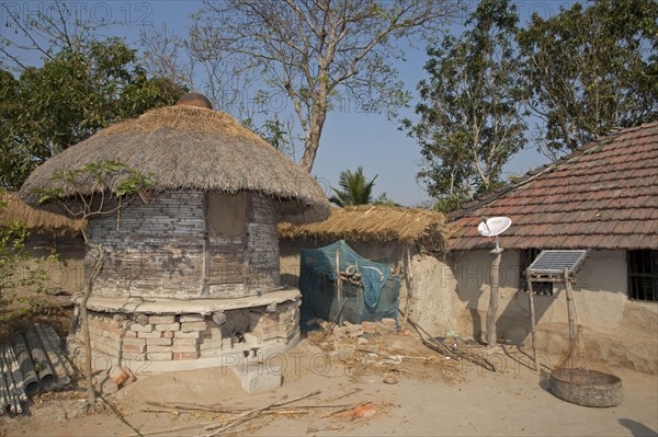 Old-fashioned granary with modern satellite dish and solar panel