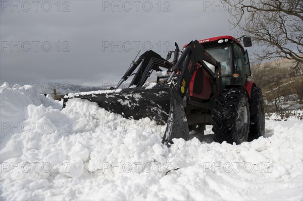 Zetor tractor with loader clears snow from blocked country road after snowstorm