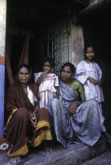 Fisher women sitting infront of the house