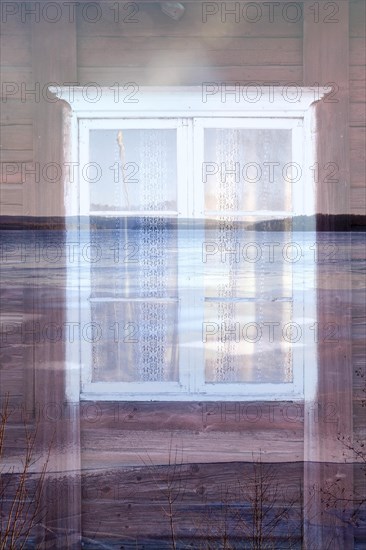 Doppelbelichtung. Erste Belichtung ein weisses Holzfenster in alter roter Blockhausfassade. Zweite Belichtung zeigt den Blick aus dem Fenster auf den See Vaermeln