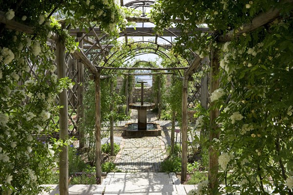 Trellis arch and water feature in the herb garden