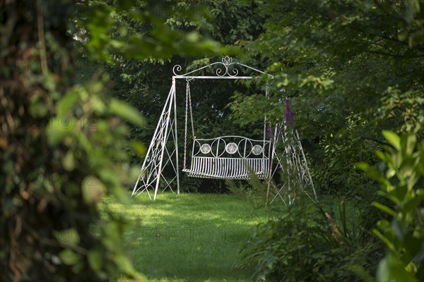 Swinging garden seat on lawn in garden