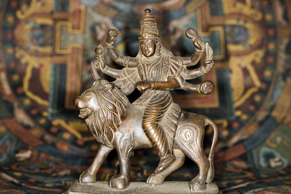 Bronze figure of the Indian goddess Durga riding on a lion figurine