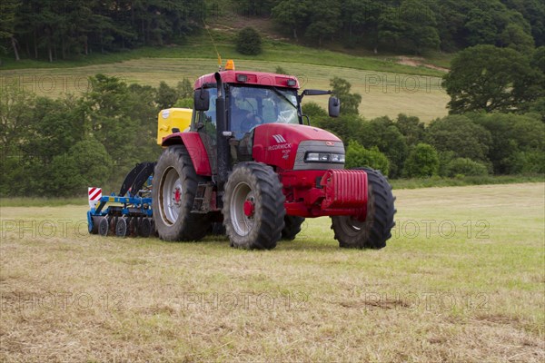 Contractor with McCormick MC120 tractor and ERTH Agriseeder precision slot seeder