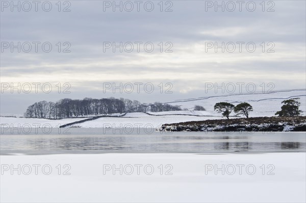 View of a partially frozen and snow-covered glacial lake