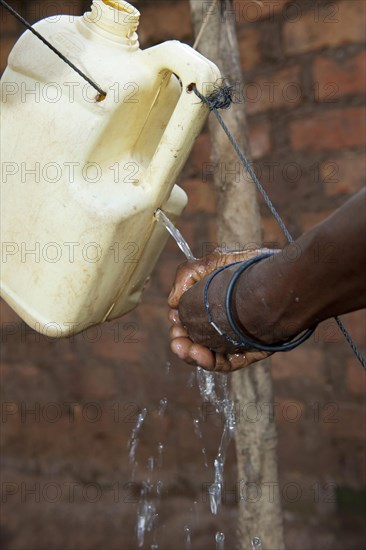 Woman washes hands under homemade tap