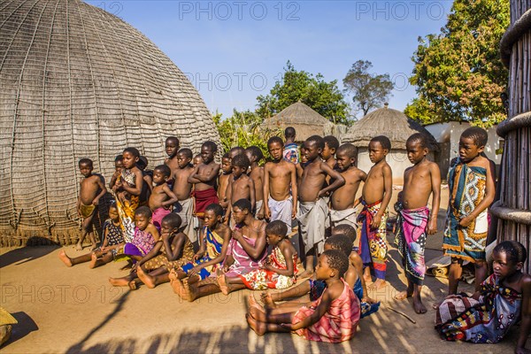 Children watch with interest at traditional customs in real African village