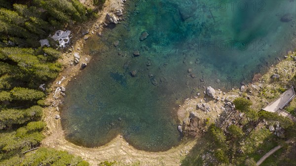 View of of turquoise blue water of Lago di Carezza and Latemar Group mountains