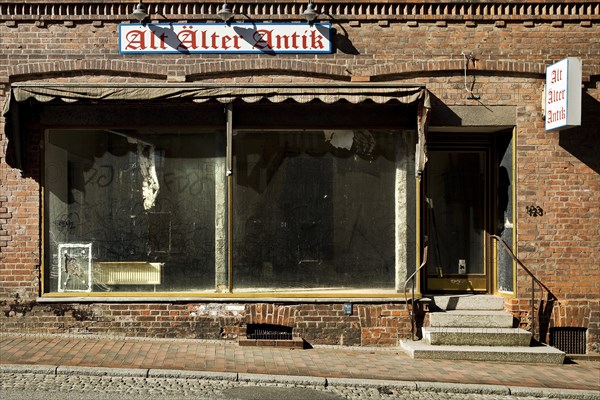 Schmutzige Schaufenster des leerstehenden Ladengeschaeftes Alt