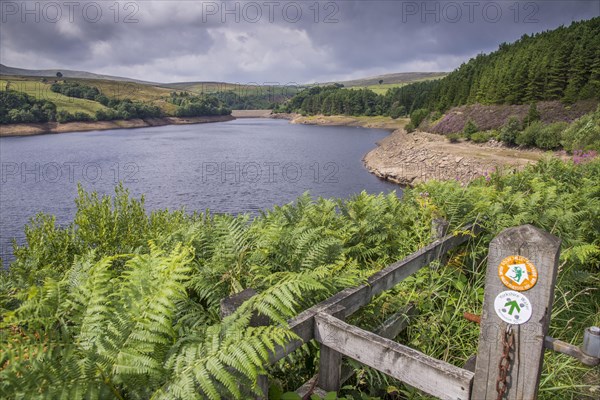 View of manmade reservoir with 'Holme Valley Riverside Way' and 'Yorkshire Water Permissive Path' signs