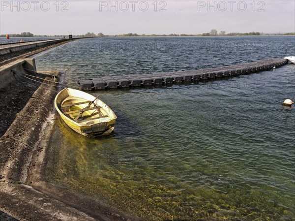 Rowing boat at edge of manmade reservoir