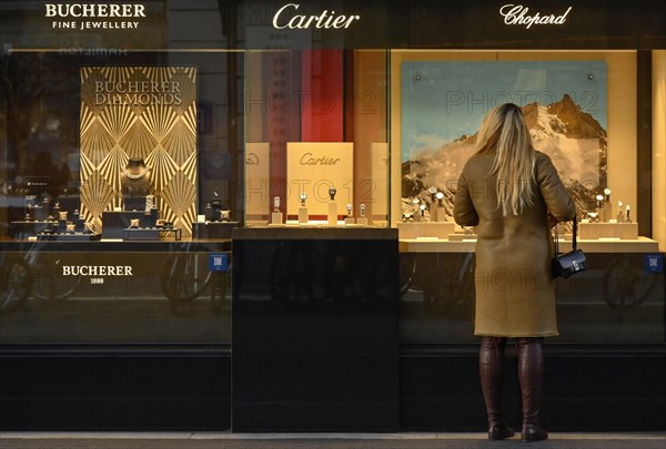 Frau steht vor Schaufenster Juweliergeschaeft