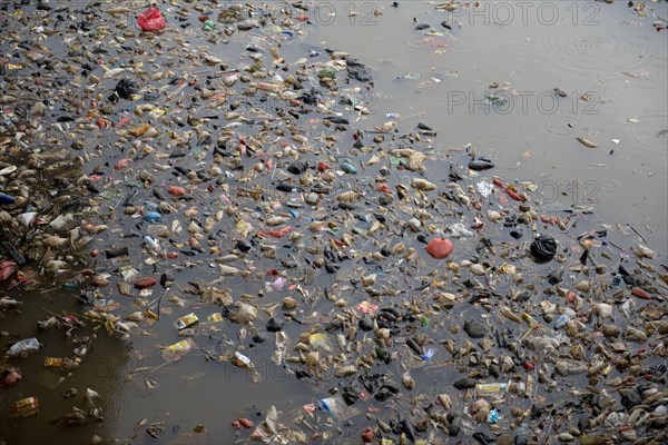 Rubbish floating on river in city