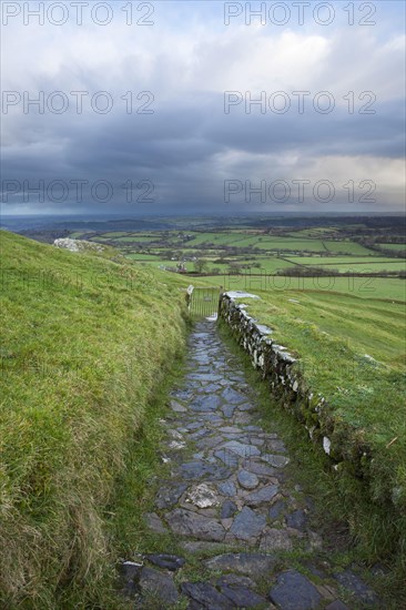 View of path and gate leading from 13th century church onto moorland at sunrise