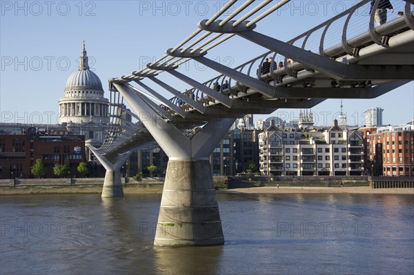 Pedestrians crossing river on steel suspension bridge