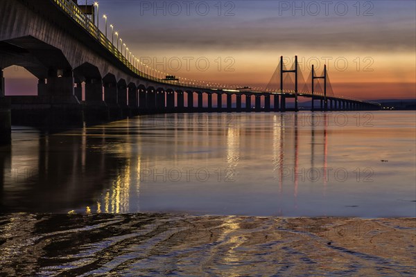 View of road bridge over river at sunset