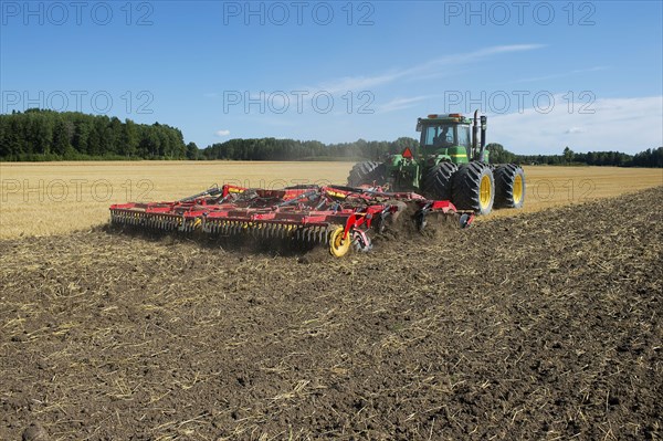 John Deere 9400 pulling Vaderstad TopDown 700 cultivator and tilling stubble field