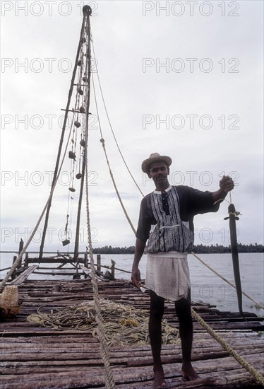 Fisher man with his catch eel fish standing above the Chinese Fishing net