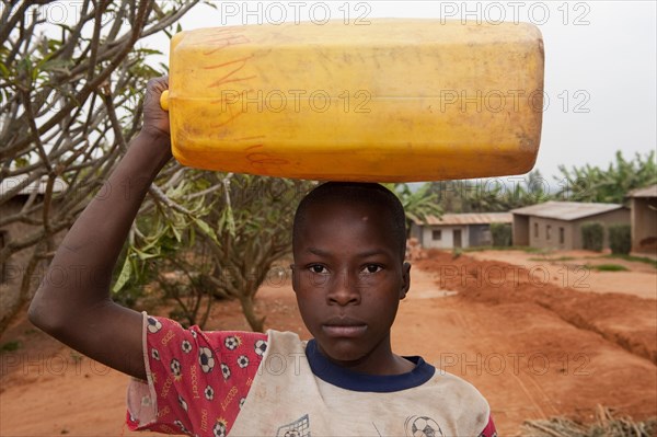 Children collecting water from a well and carrying it home