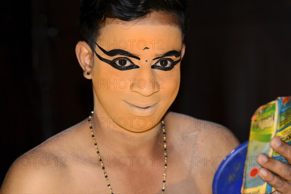 Kathakali dancer putting on make-up