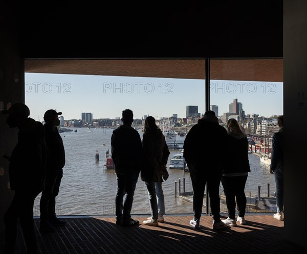 Visitors standing at the window of the public viewing platform