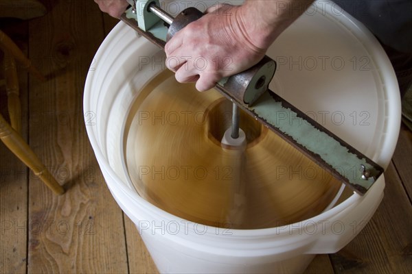 The honeycomb frames are placed in a centrifugal drum and then spun at high speed to separate the honey from the combs