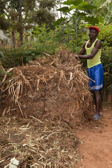 Farmer standing next to compost heap