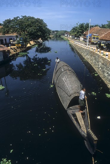 Men Pushing Kettuvallam in the Backwaters of Alappuzha