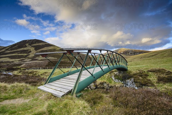 Metal footbridge over the river in Glen