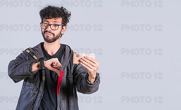 Unhappy person with a Nicaraguan banknote with his thumb down