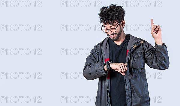 Isolated person looking at his watch and raising his finger