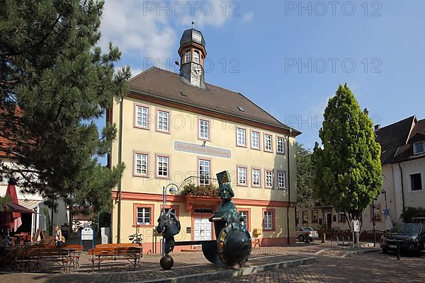 Market square with town hall and music school and sculpture by Juergen Goertz in Mingolsheim