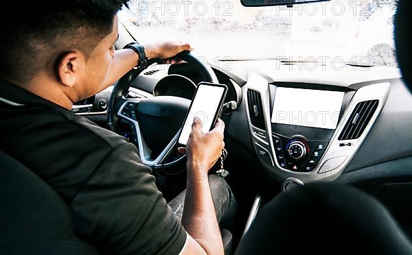 Person holding the cell phone and with the other hand the steering wheel