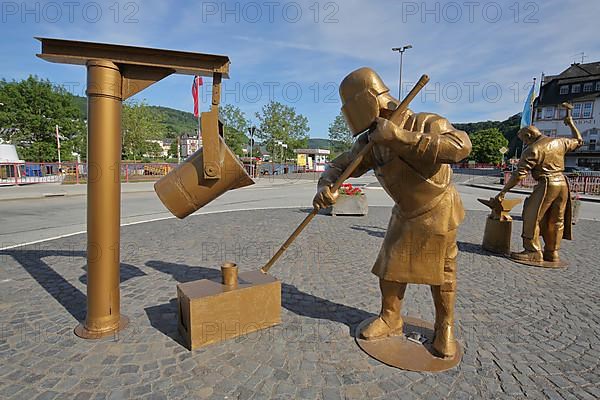 Golden sculptures with workers for steel production and steel processing with tools in the foundry in Alf