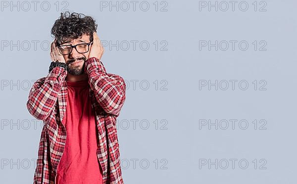 Desperate man covering his ears on isolated background