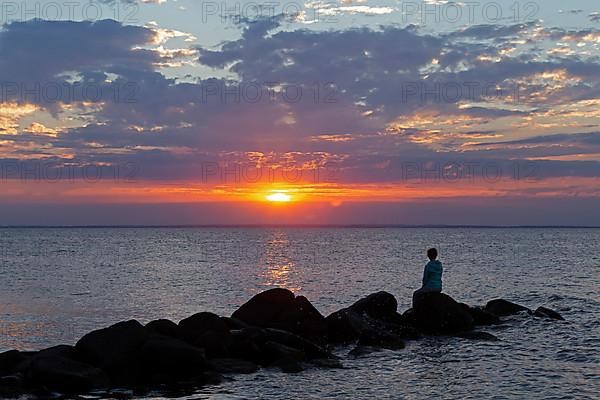 Woman sitting on stones