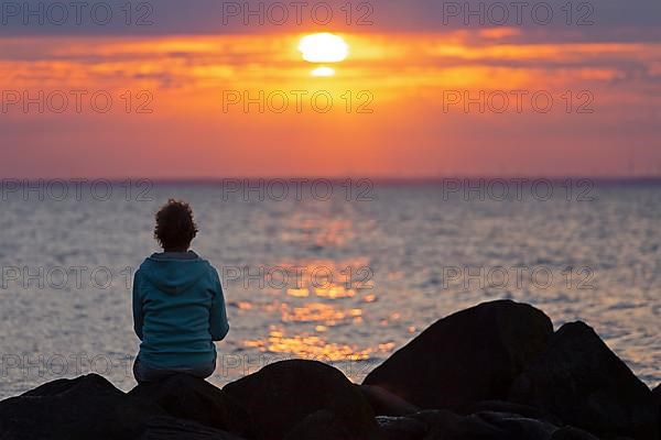 Woman sitting on stones