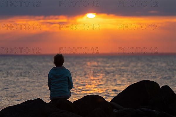 Woman sitting on stones