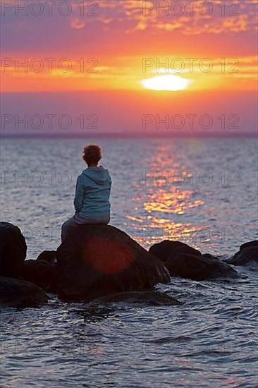 Woman sitting on stones