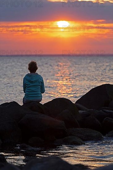 Woman sitting on stones