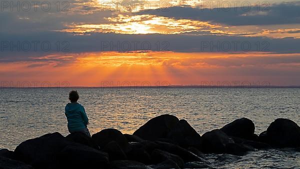 Woman sitting on stones