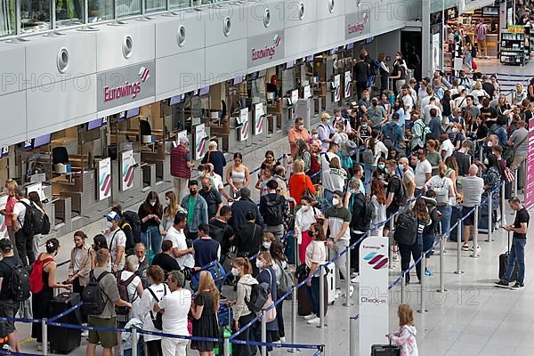 Passengers wait for check-in in front of the Eurowings check-in counter