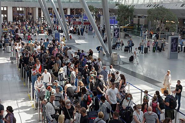 Passengers waiting for check-in in front of the check-in counter