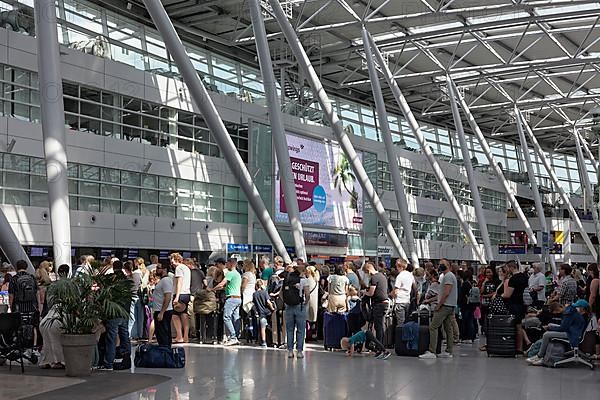 Passengers waiting for check-in in front of the check-in counter