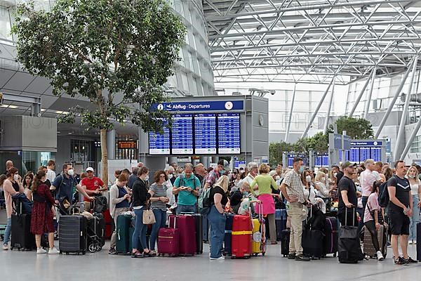 Passengers waiting for check-in in front of the check-in counter