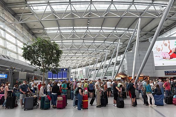 Passengers waiting for check-in in front of the check-in counter