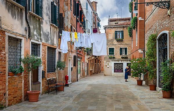 Laundry on a line in front of the typical Venetian house facades in the lagoon city of Venice