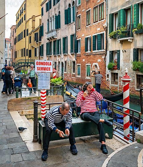 Gondolliers in the lagoon city waiting for tourists