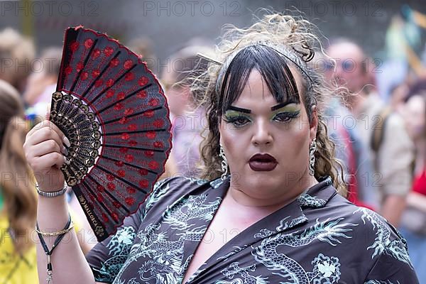 Made-up transvestite with fan at the CSD parade