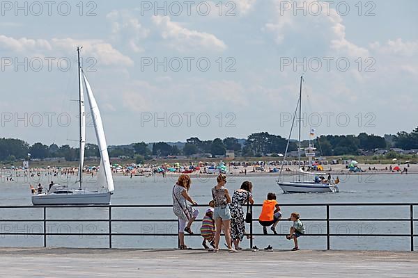 Family looking across the river Trave to the beach of Priwall